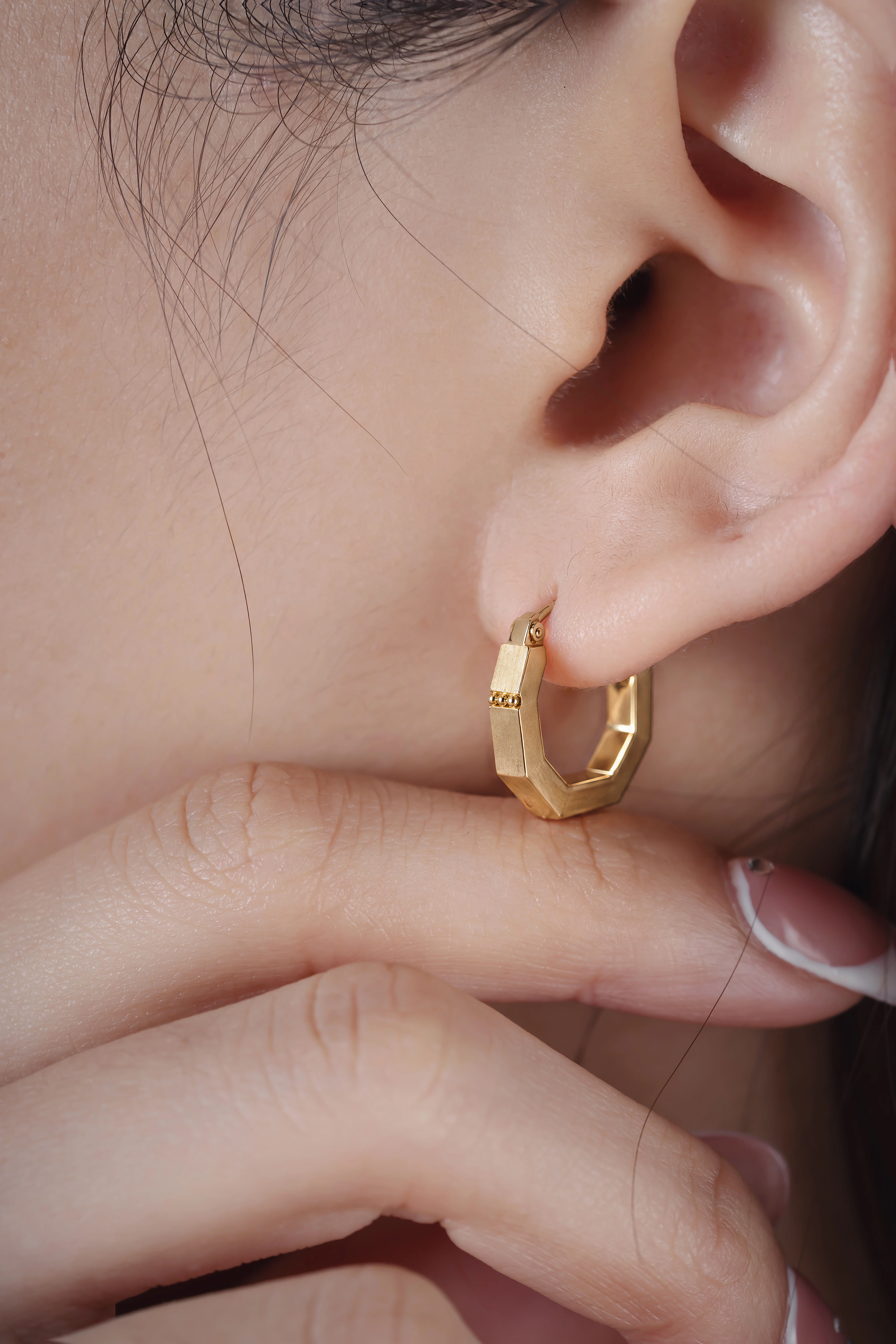 Close view of an ear wearing the octagonal VÉRA Arc Hoop