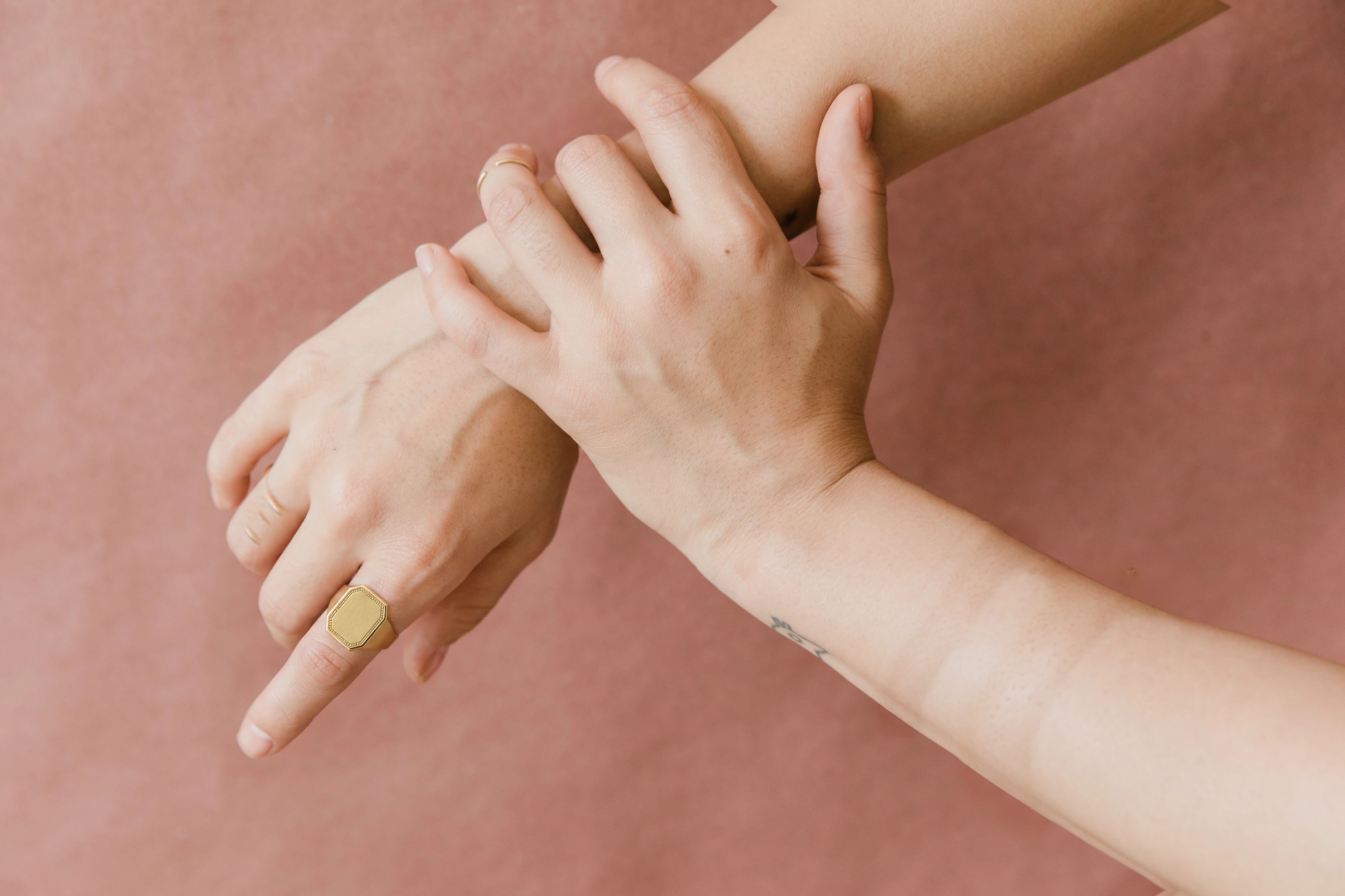 Hands wearing gold rings and a bracelet