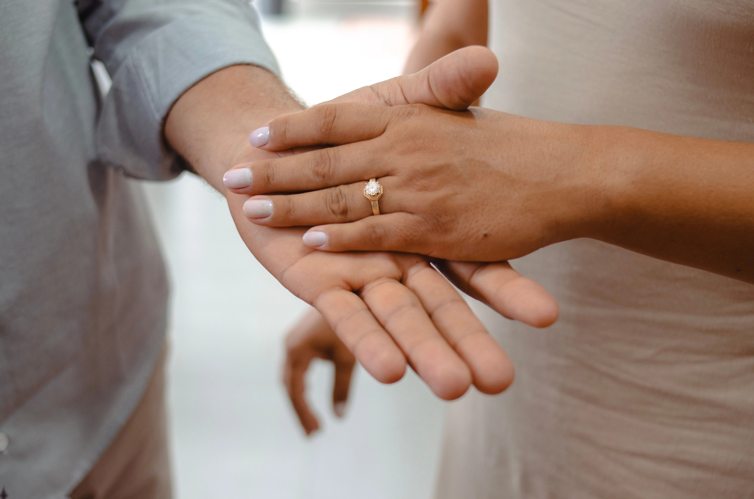 Hands wearing gold rings and stacked bracelets