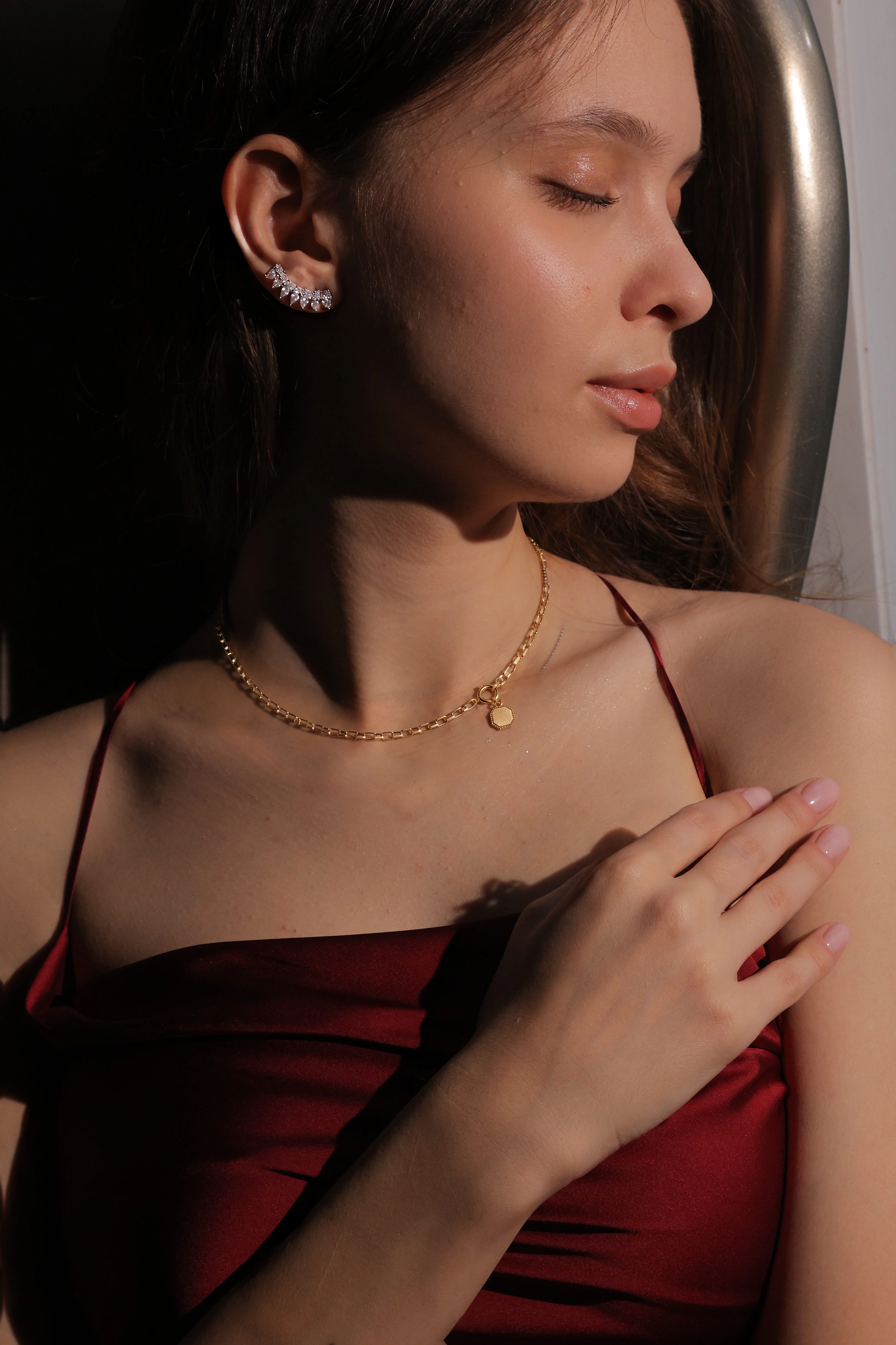 A woman in a red silk top wearing the VÉRA Fil Chain Necklace