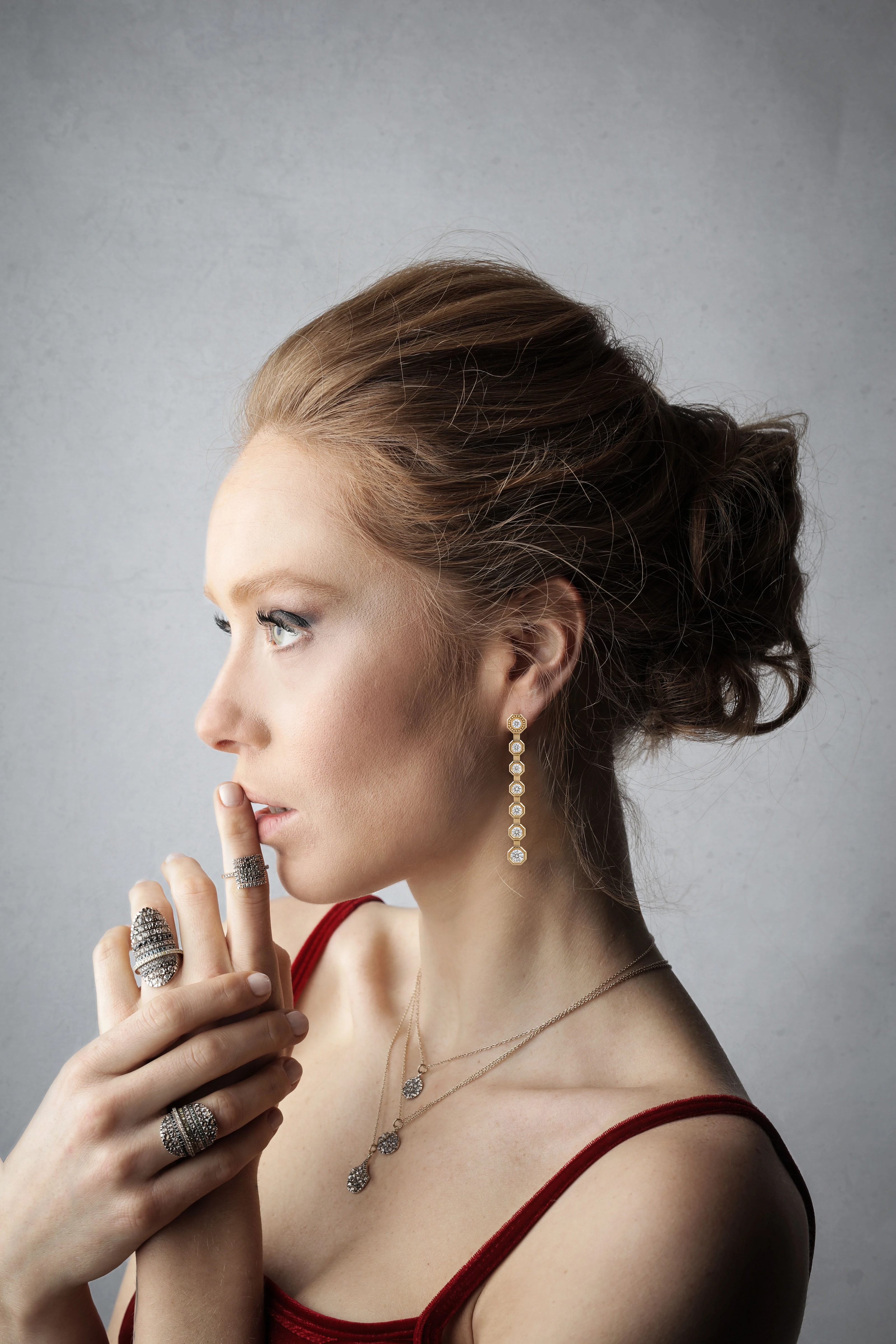 A woman in profile wearing gold drop earrings