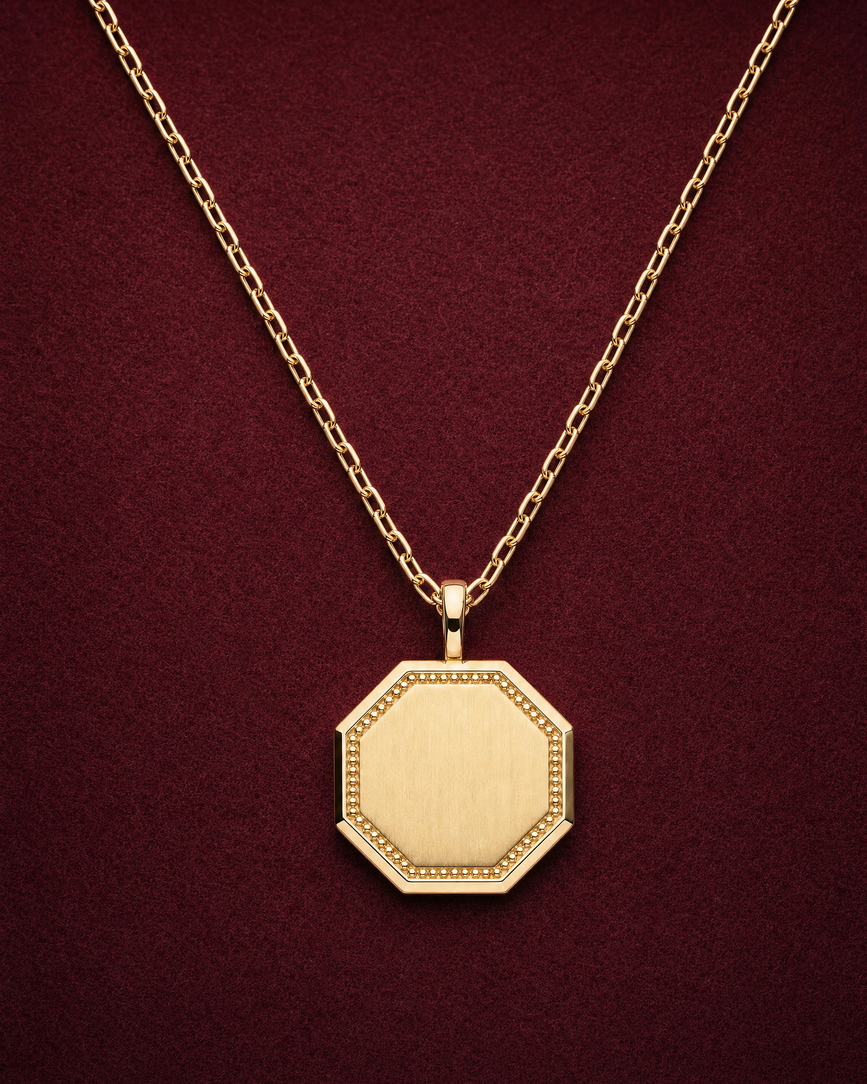 Medallion Necklace with a blank octagonal 14k gold pendant framed by gold granules, on garnet jeweler's felt