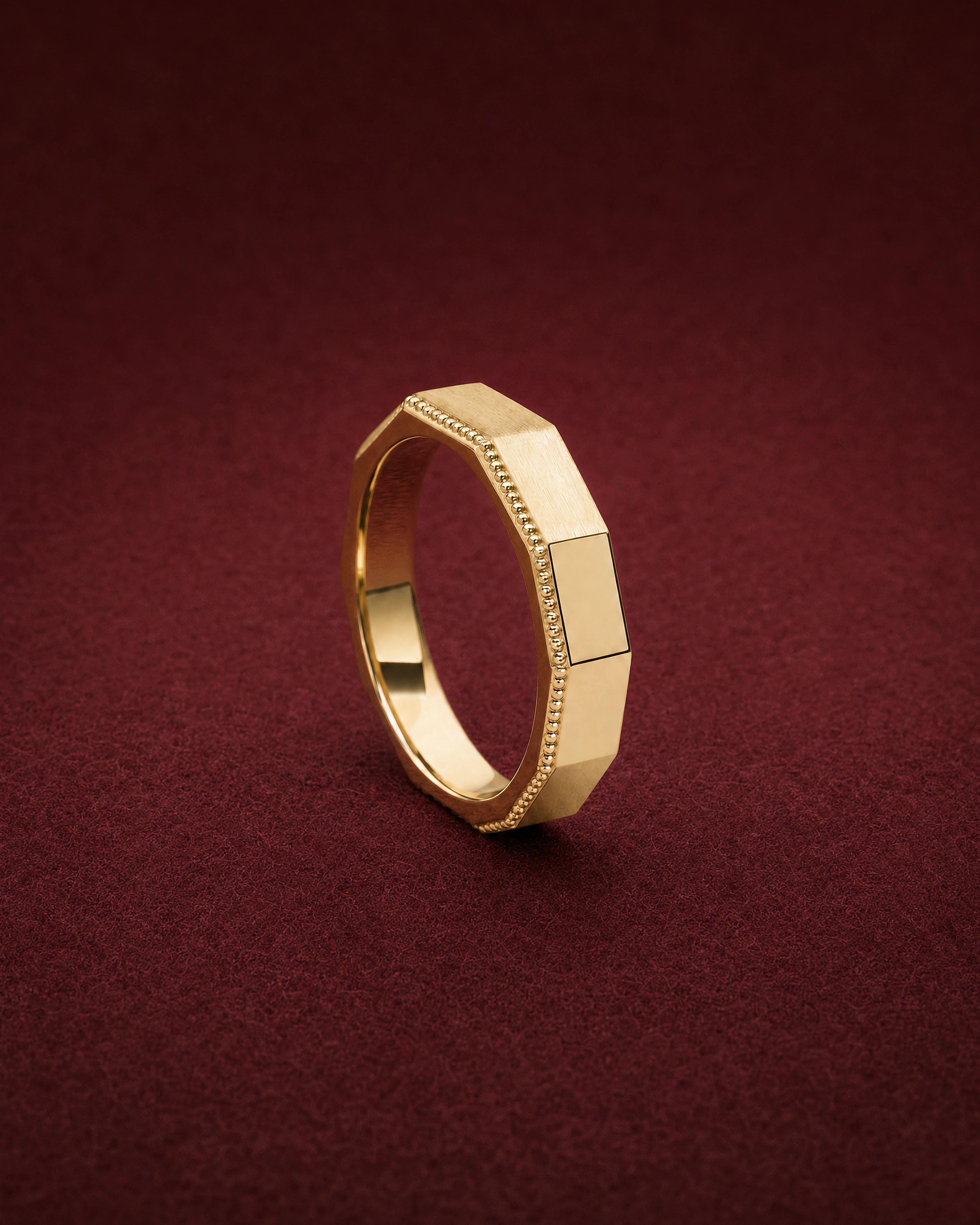 Orra Band in 18k yellow gold with an eight-sided profile and a granule edge, on garnet jeweler's felt