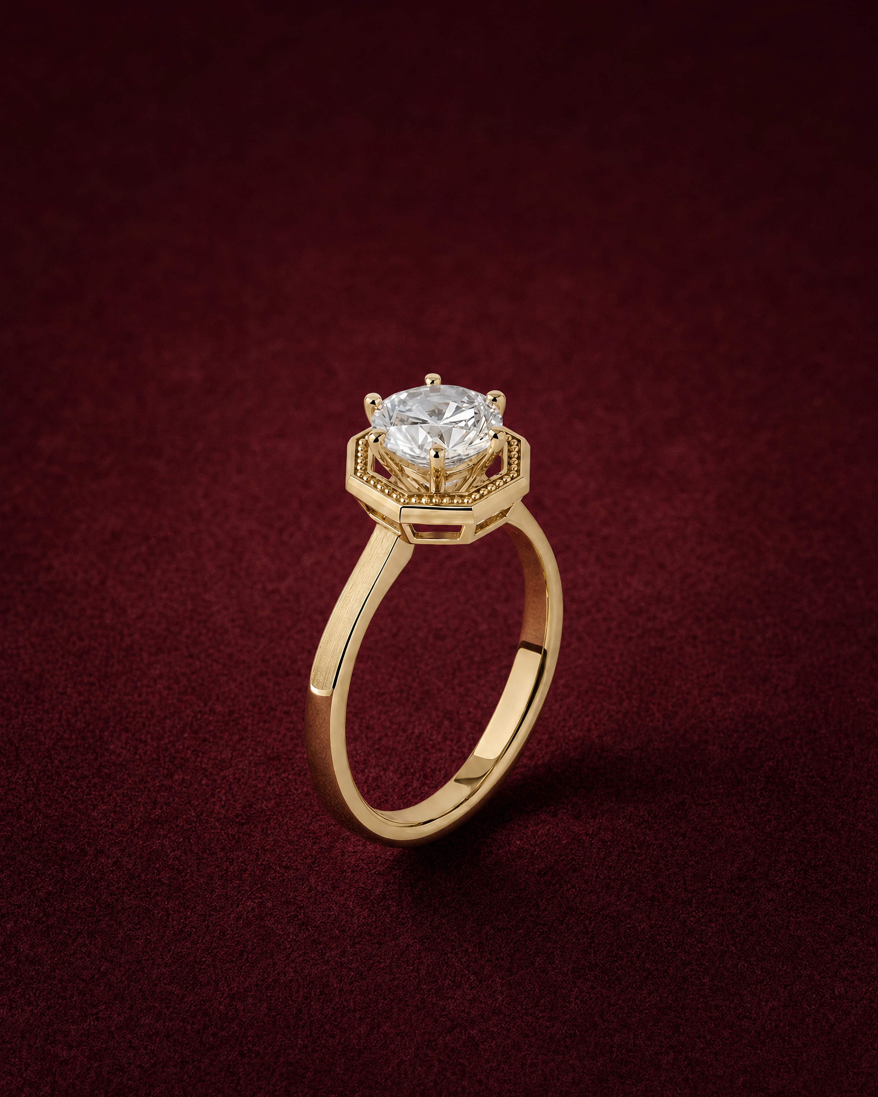 Vera Solitaire with a round diamond on an octagonal 18k gold gallery, on garnet jeweler's felt
