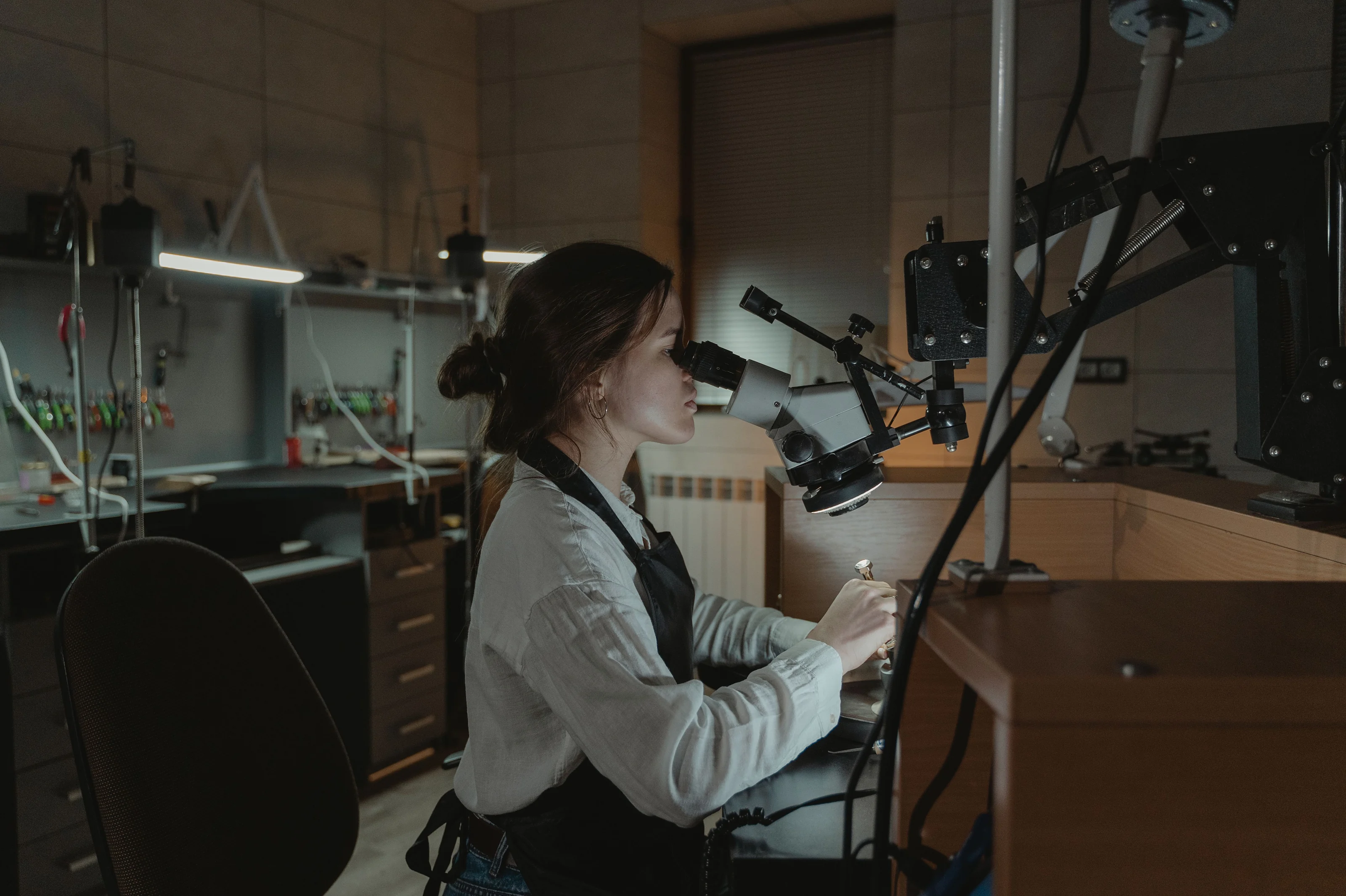 The studio workbench with a microscope, lamps and hand tools