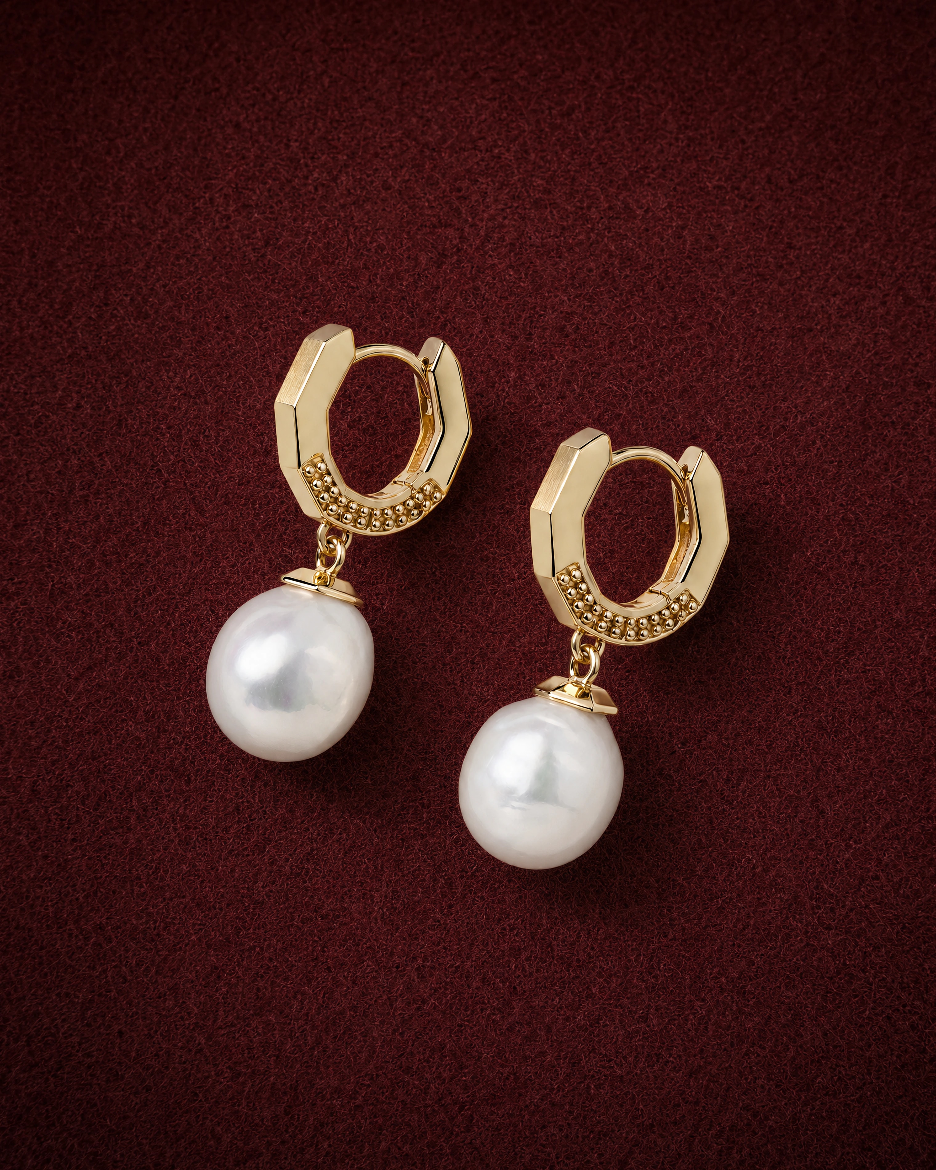 Pearl Drop Earrings with baroque pearls under octagonal gold caps on faceted huggies, on garnet jeweler's felt