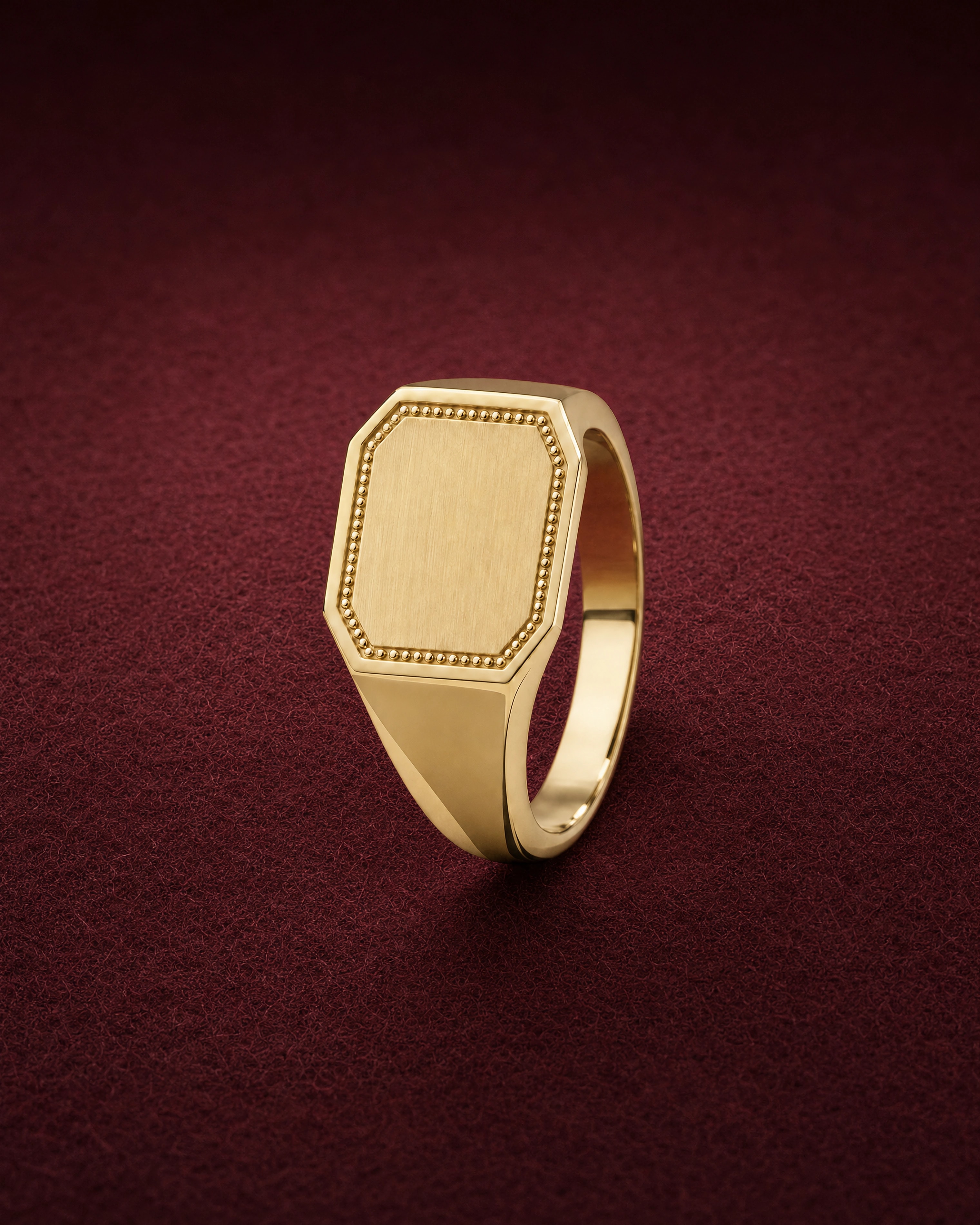Sola Signet in 14k yellow gold with an octagonal satin face framed by gold granules, on garnet jeweler's felt